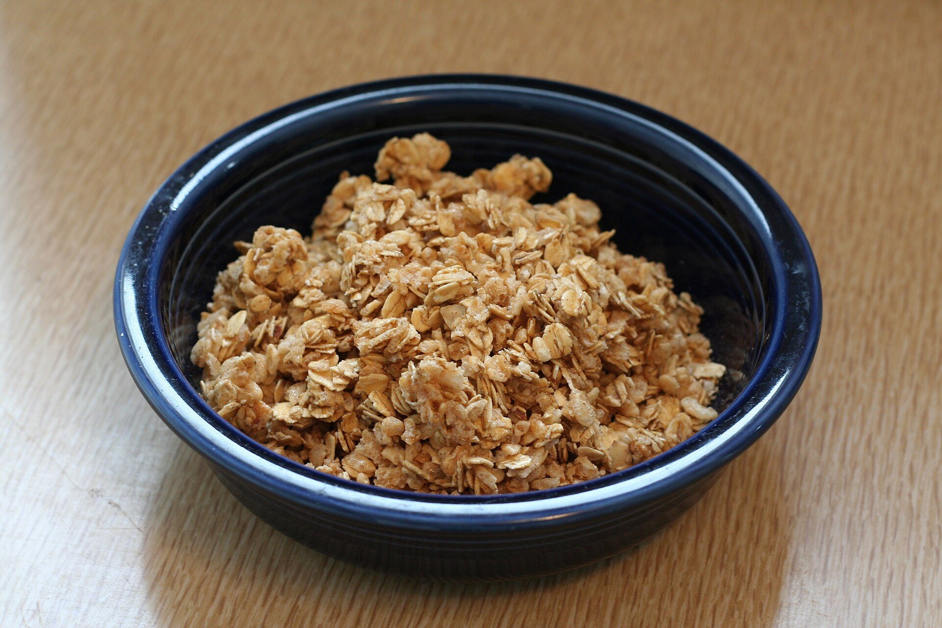 Homemade oat granola in a dark blue bowl